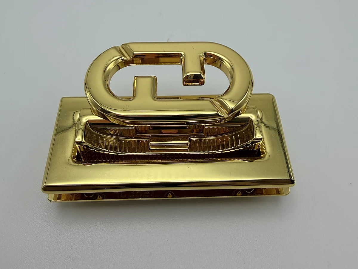Gold-tone architectural handbag lock with a rectangular base