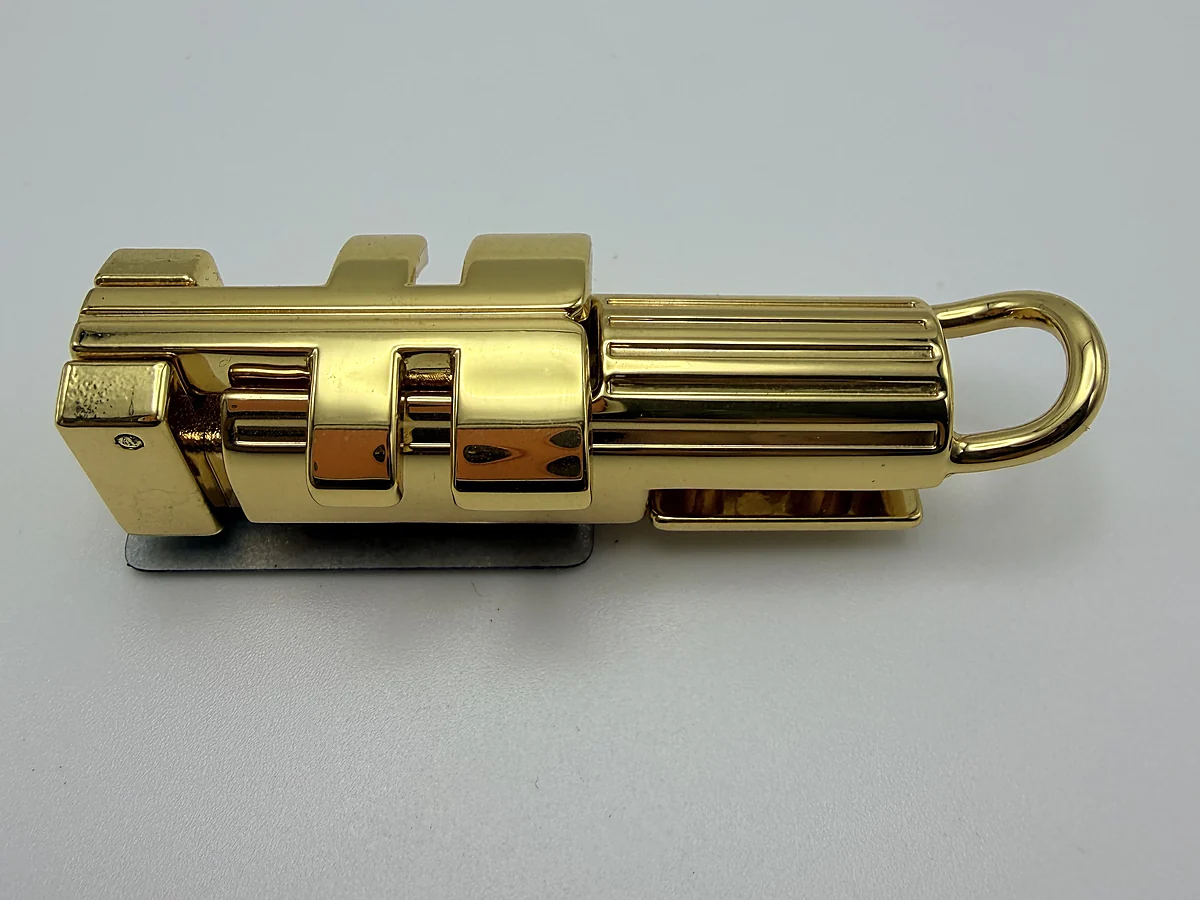 Polished gold cylindrical handbag closure
